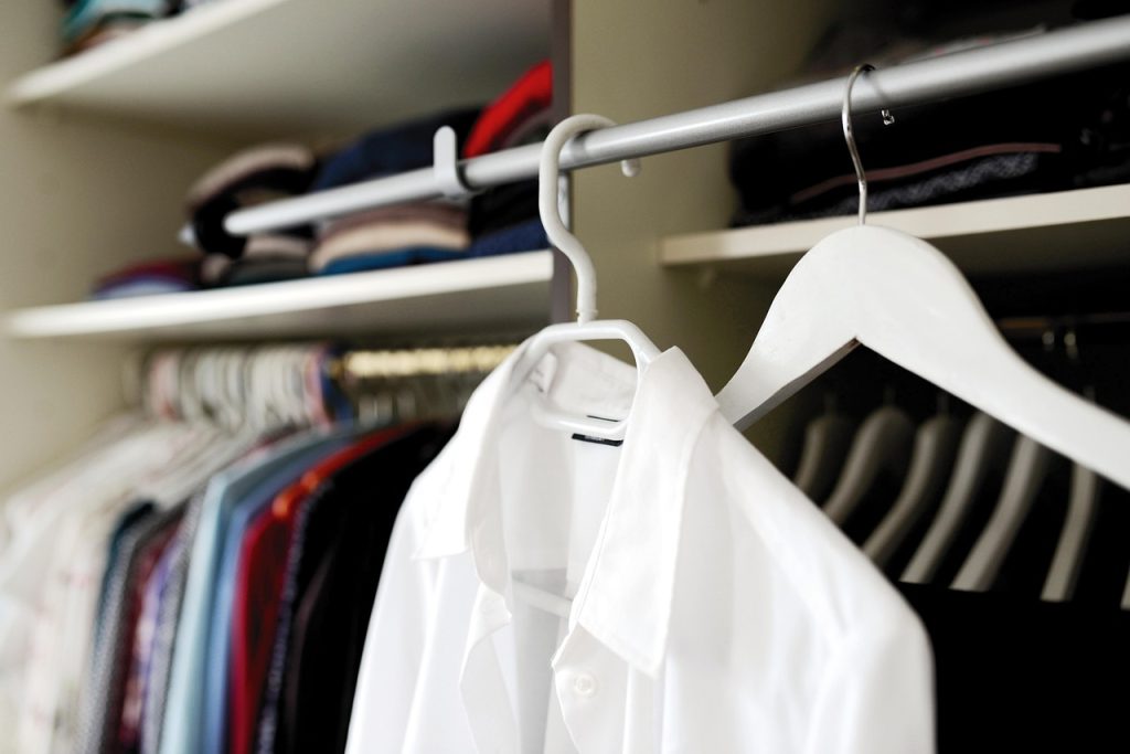 small electric dehumidifier next to clothing rack in dressing room
