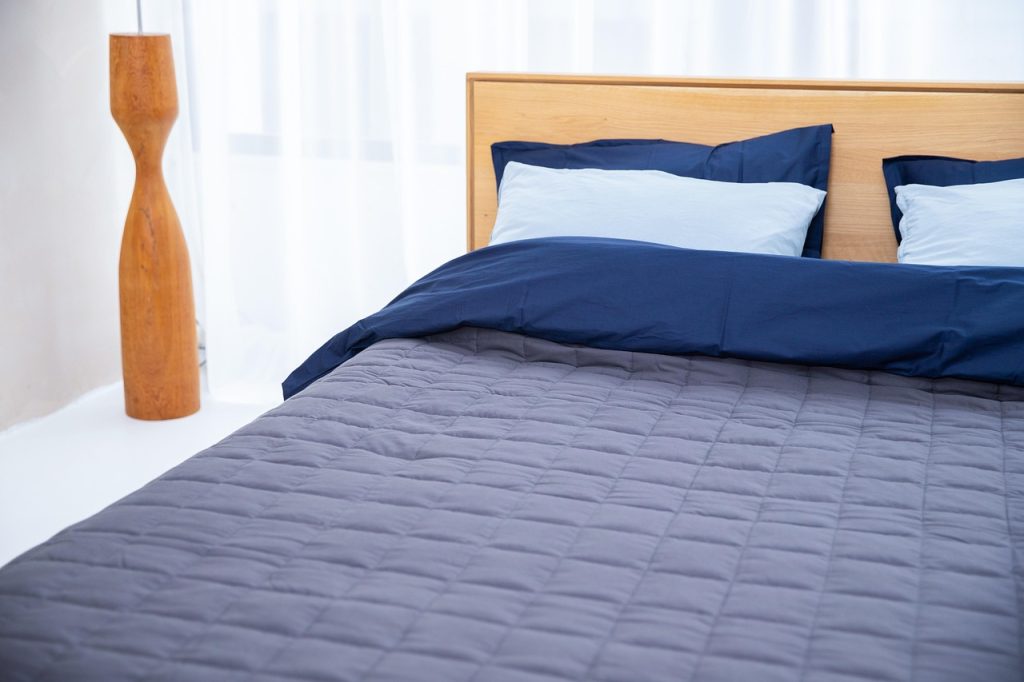white mattress protector cover with zipper being put on mattress