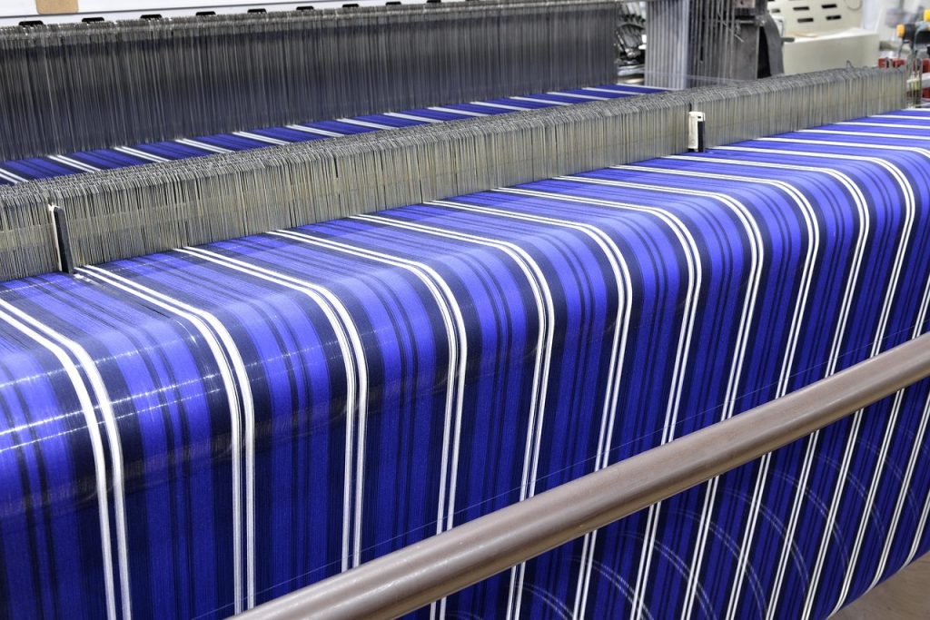 cotton swab applying hand sanitizer to ink stain on polyester fabric