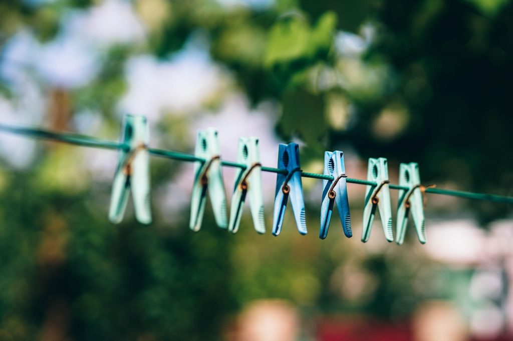 white towels drying in bright sunlight outdoors on clothesline