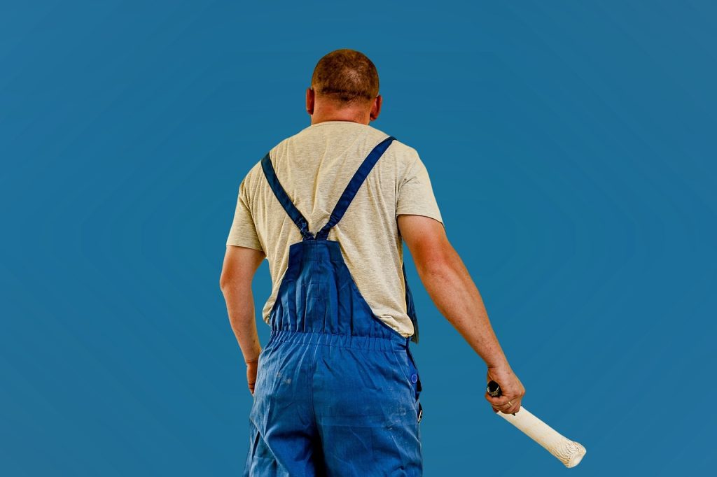 applying anti-mold coating paint on a clean white wall with a roller brush