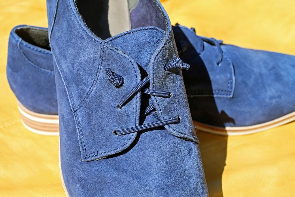 different shoe materials including leather suede mesh sneakers laid on flat surface