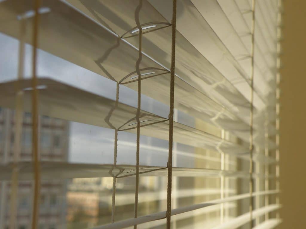 microfiber blind cleaning glove being used on window blinds