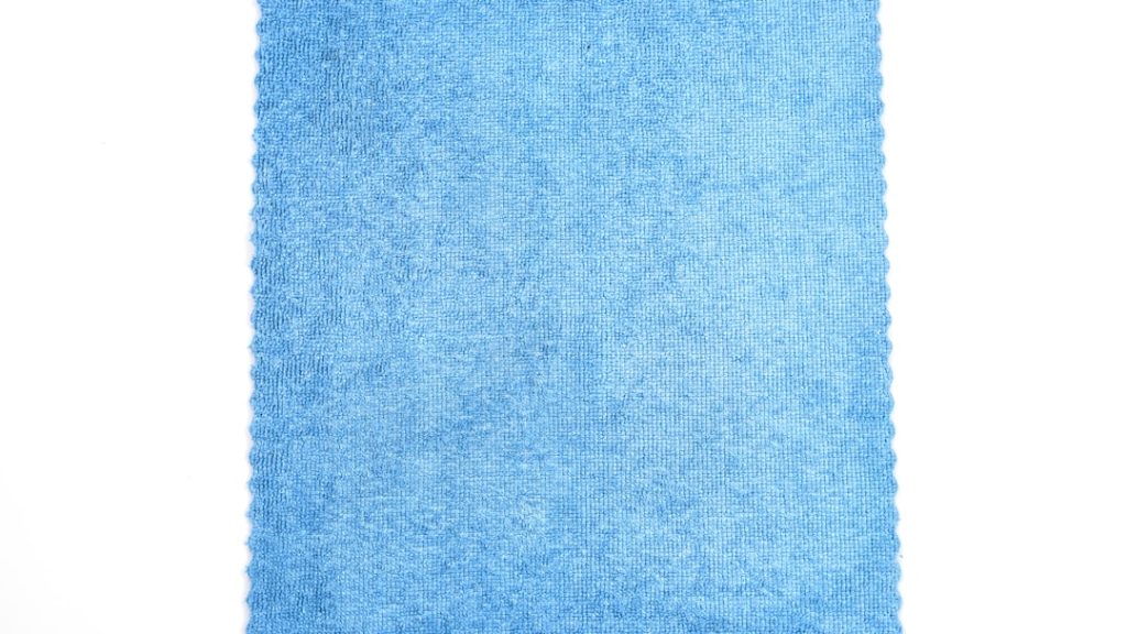 cleaning tools for blinds laid out on white surface - brush, gloves, lint roller