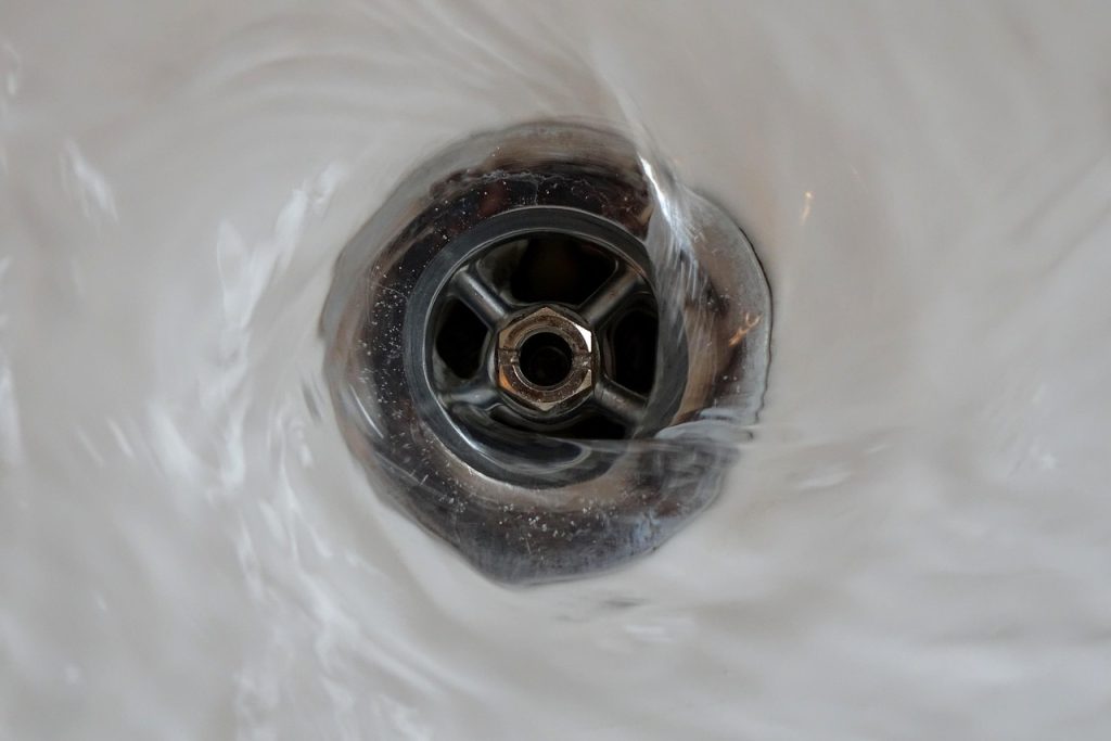 bathroom sink drain with hair buildup visible