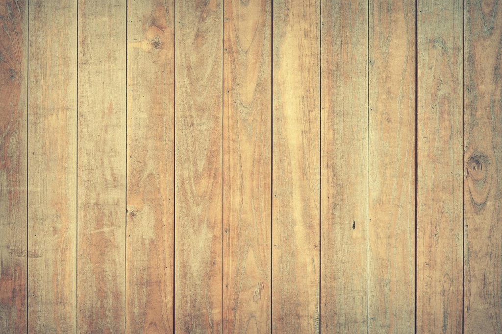 three types of flooring samples side by side, oak hardwood, laminate, and engineered wood