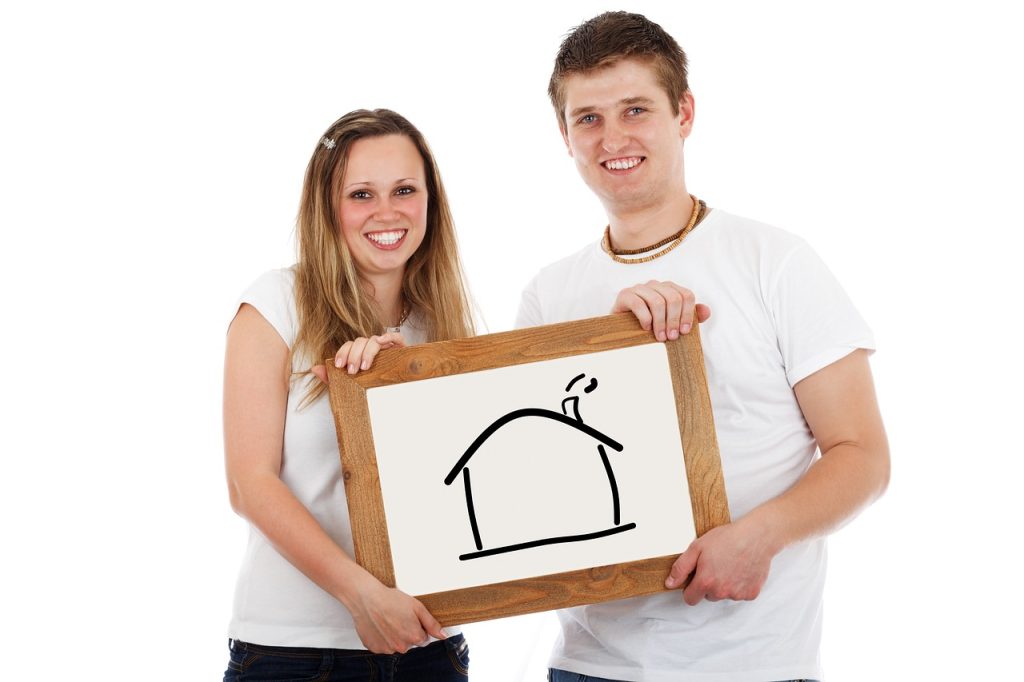 young couple receiving house key from bank officer with smiling faces