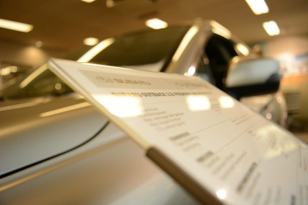 family at car dealership with disability registration documents