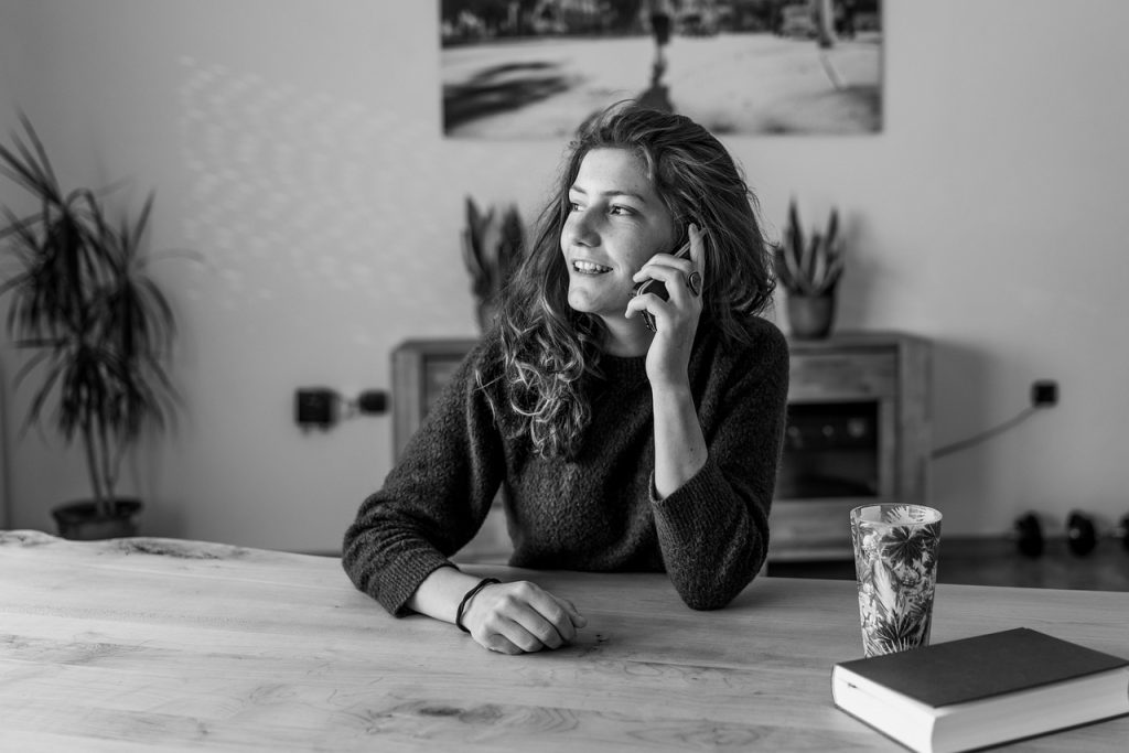woman checking healthcare app on smartphone at home desk