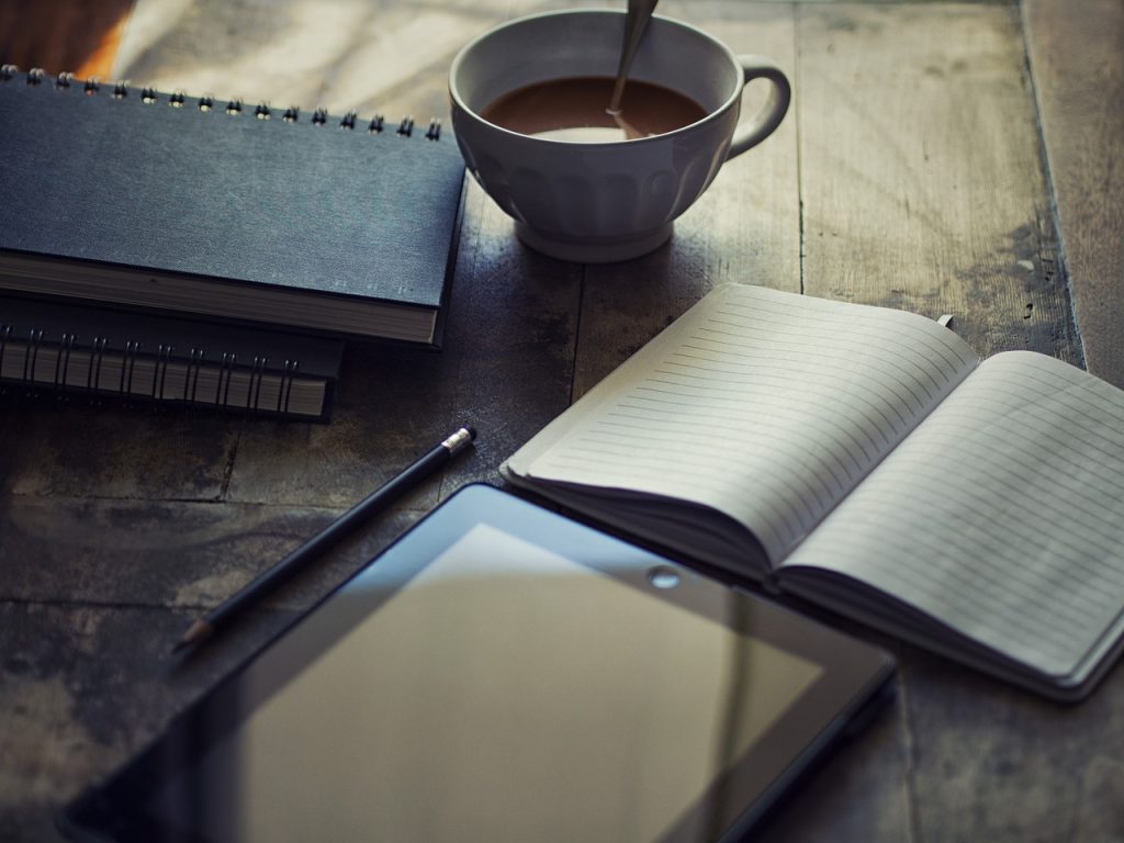 checklist on wooden desk with pen and coffee mug