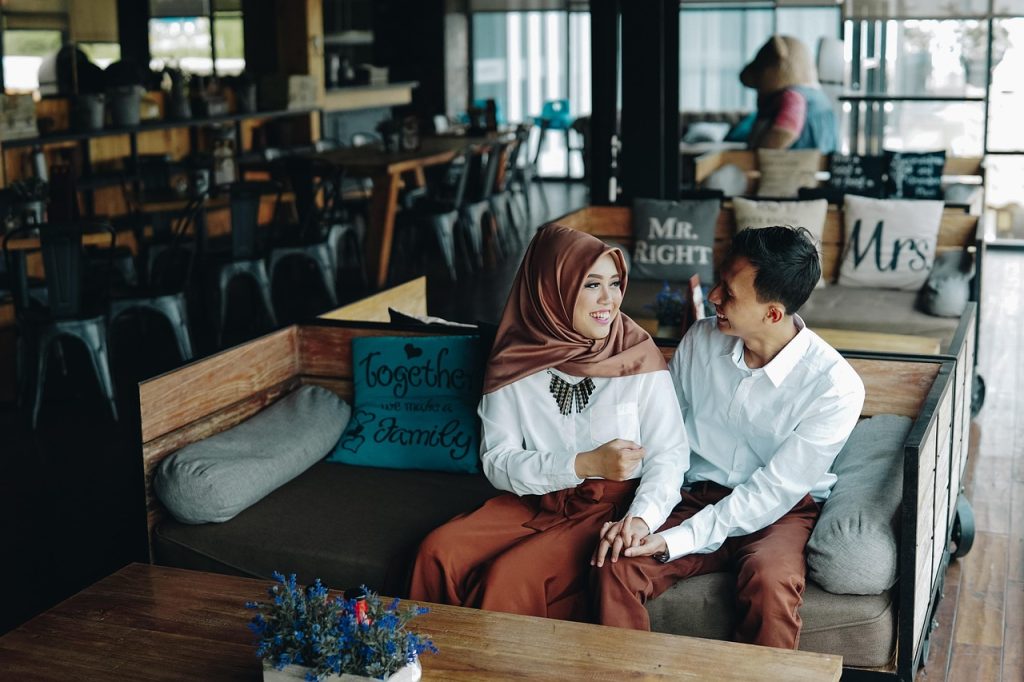 young couple checking documents together at small cafe