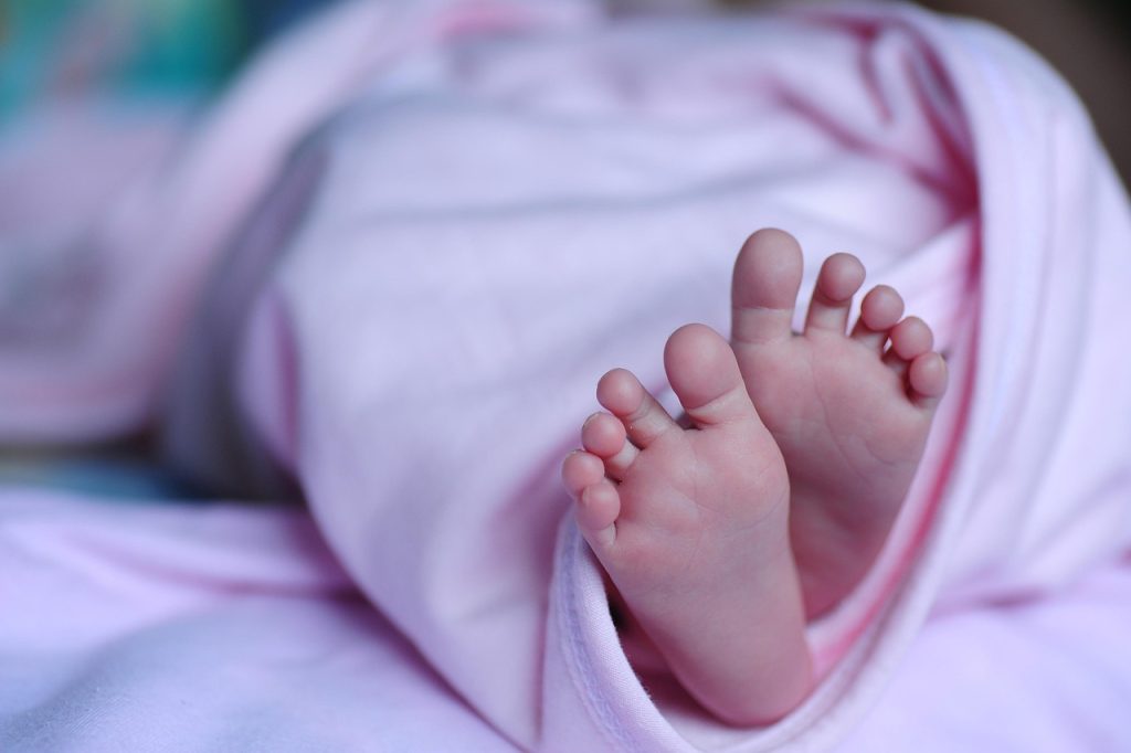 newborn baby wrapped in soft blanket with korean regional map background