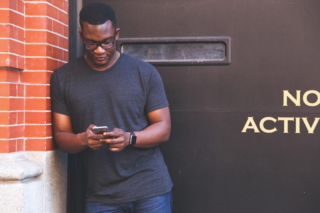 man using smartphone while baby sleeps nearby