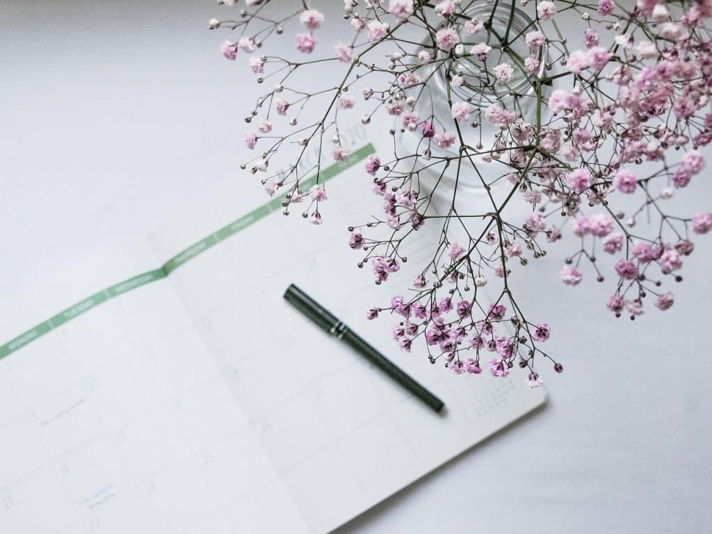 student marking important dates on a calendar with a red pen