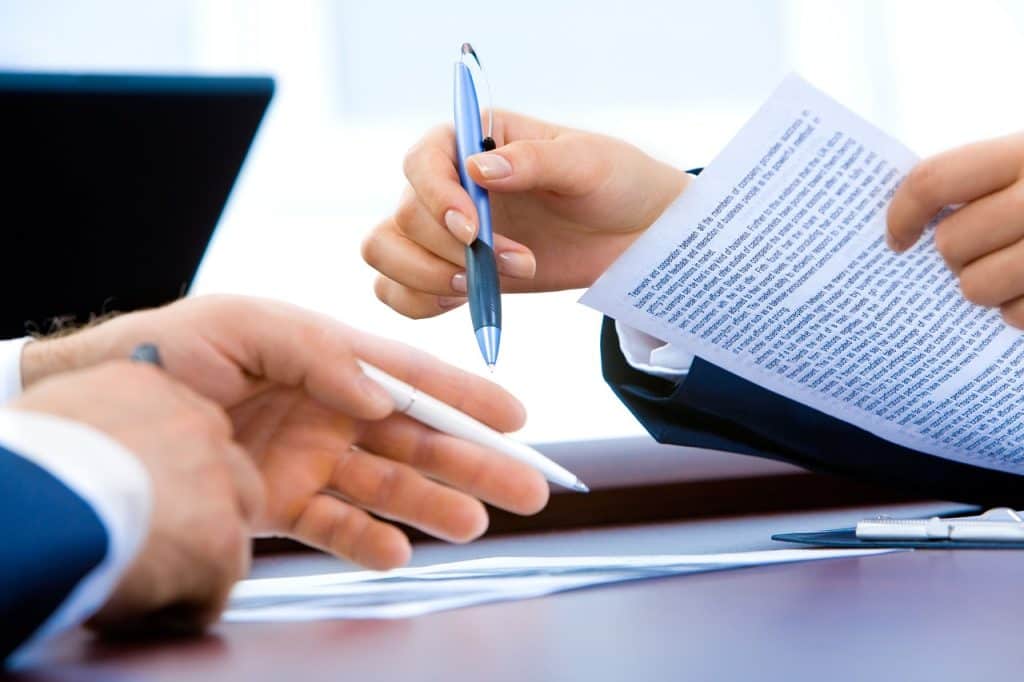 Korean small business owner reviewing closure documents at desk