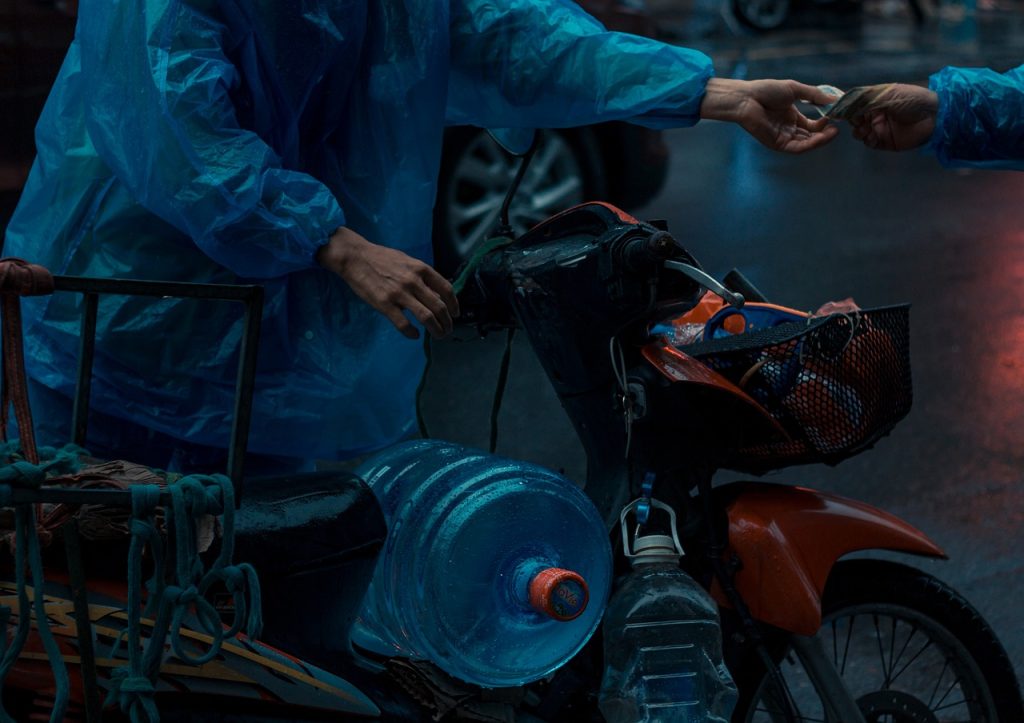 night delivery scooter parked under streetlight with paperwork on seat