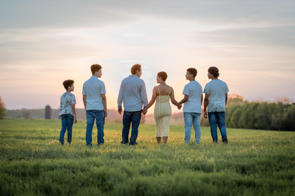 family members each holding a teal card, warm indoor lighting