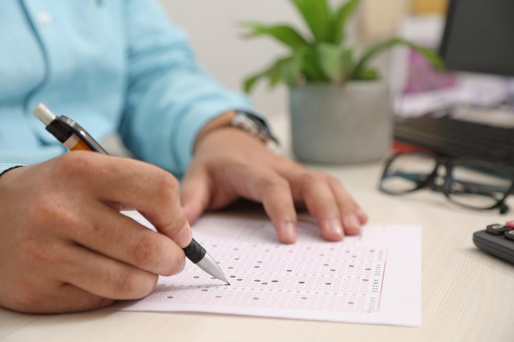 woman filling out official exemption form at a desk with natural light