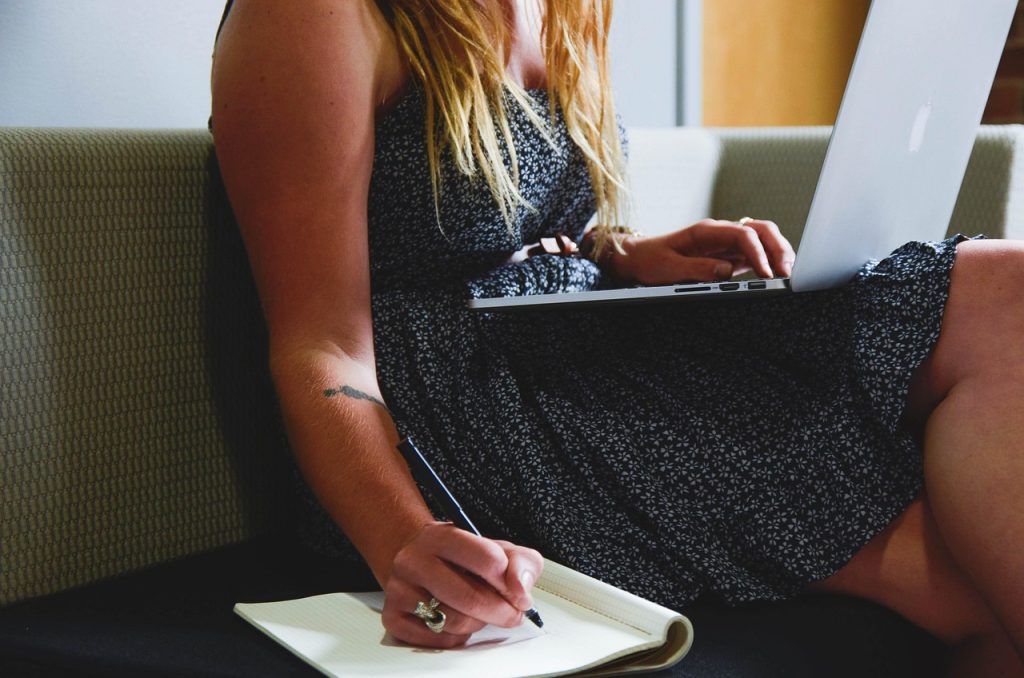 young couple planning baby budget on laptop at home